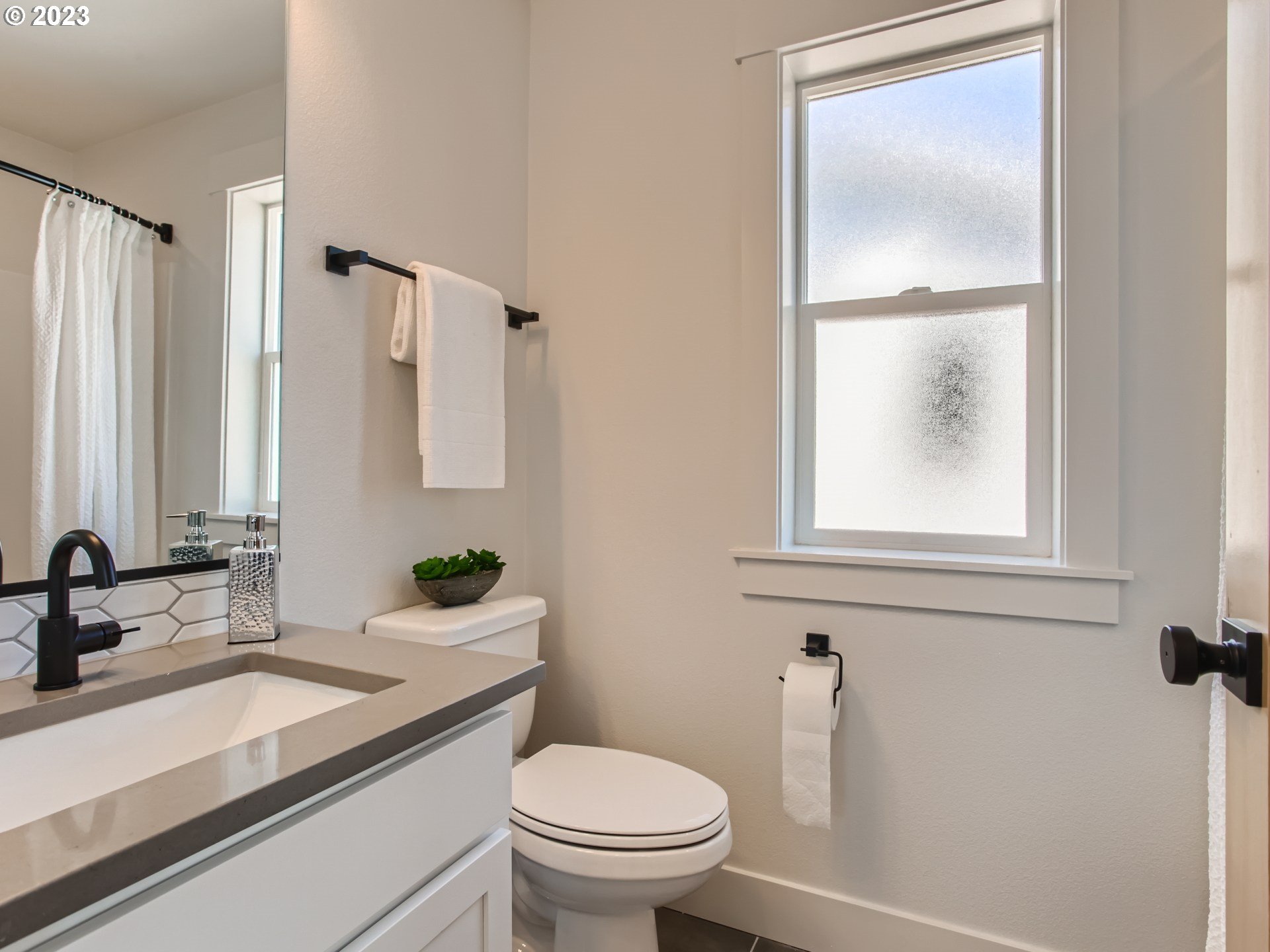 3134 North Winchell Street, Unit B Portland, OR 97217 - Photo 17 of 24 a bathroom with a sink a toilet and a mirror