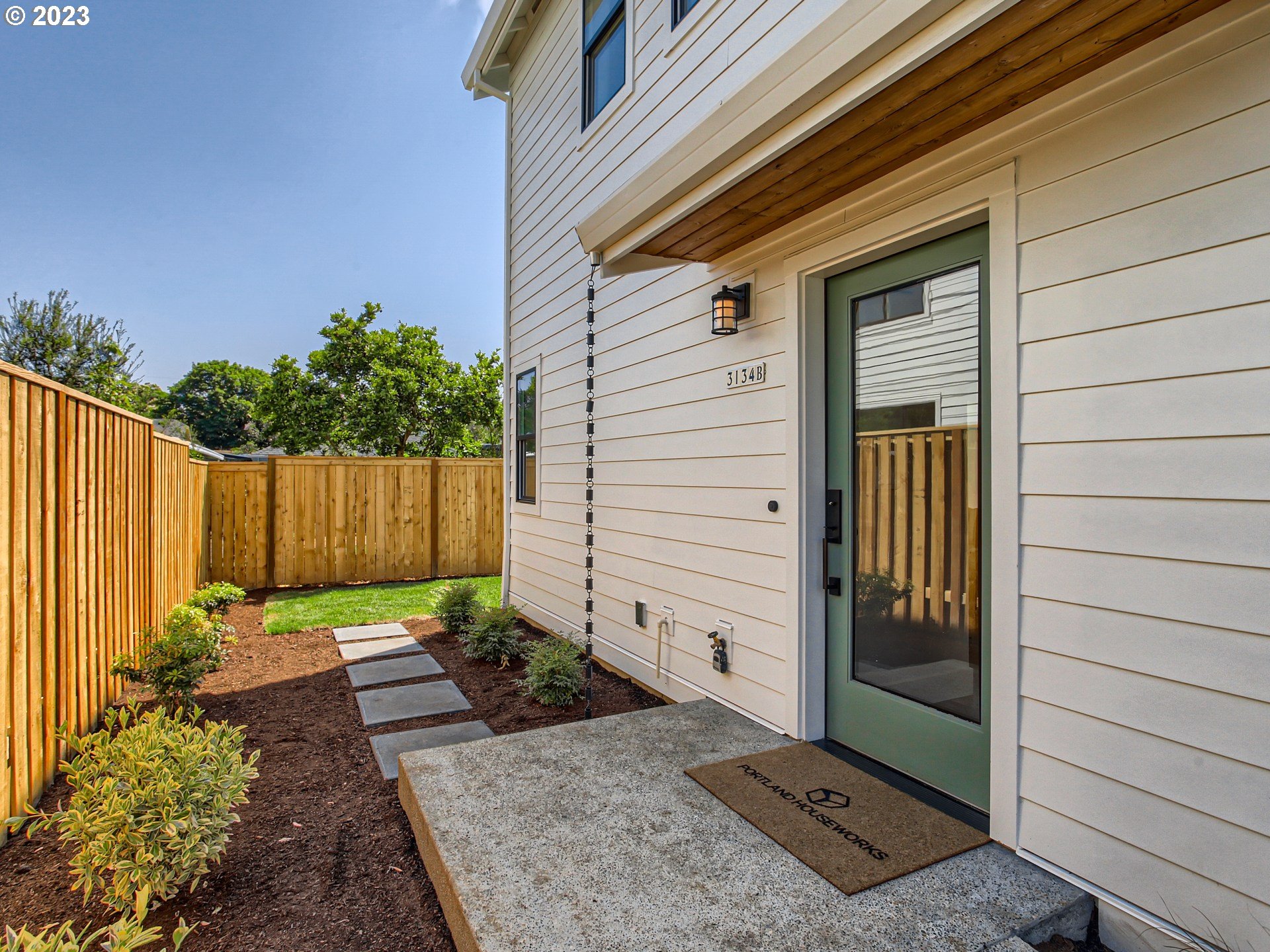 3134 North Winchell Street, Unit B Portland, OR 97217 - Photo 2 of 24 a view of backyard with potted plants and wooden fence