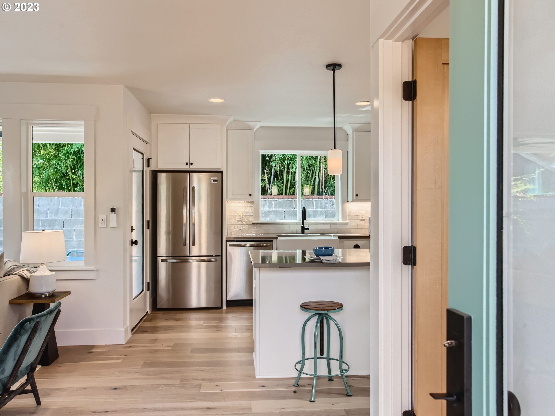 3134 North Winchell Street, Unit B Portland, OR 97217 - Photo 6 of 24 a kitchen with a refrigerator a stove and a dining table with wooden floor