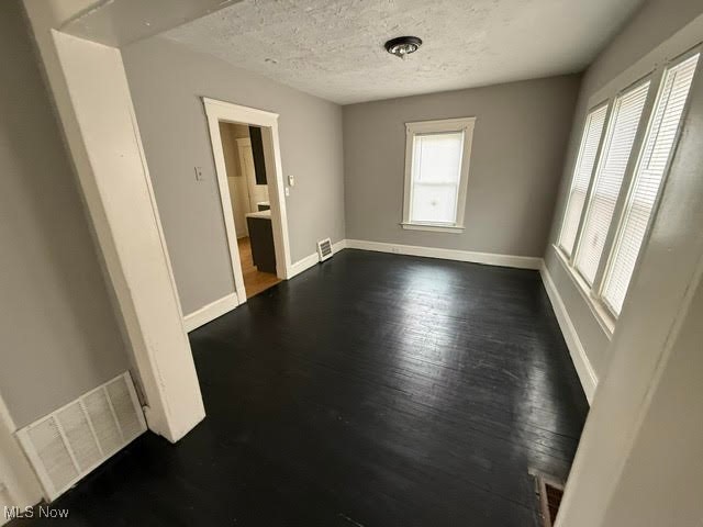 4372 Turney Road Cleveland, OH 44105 - Photo 12 of 16 Unfurnished room featuring dark wood-style flooring and a textured ceiling