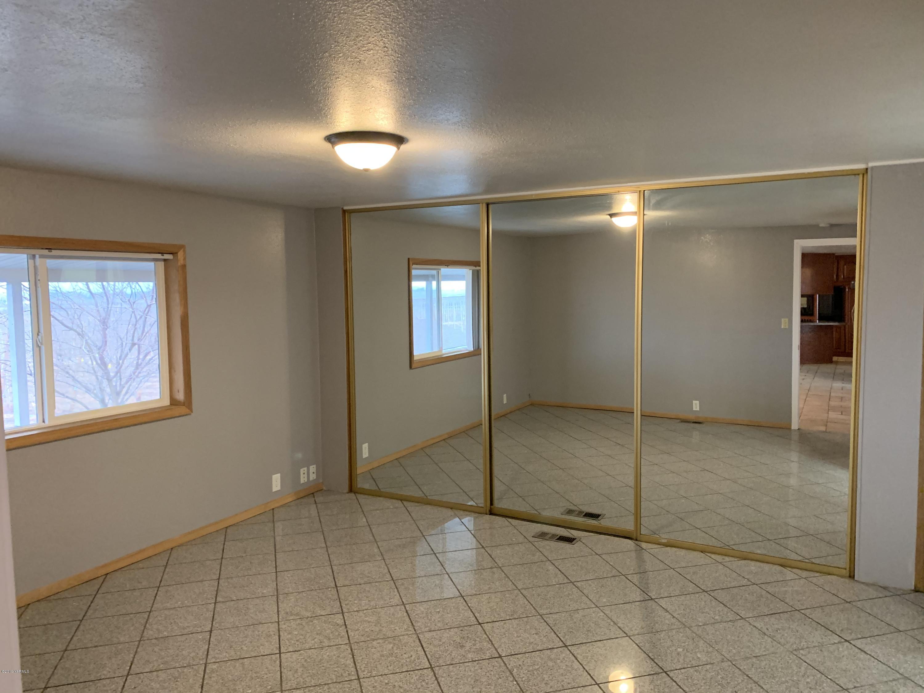 7062 Emerald Road Sunnyside, WA 98944 - Photo 21 of 37 a view of an empty room with window and chandelier fan