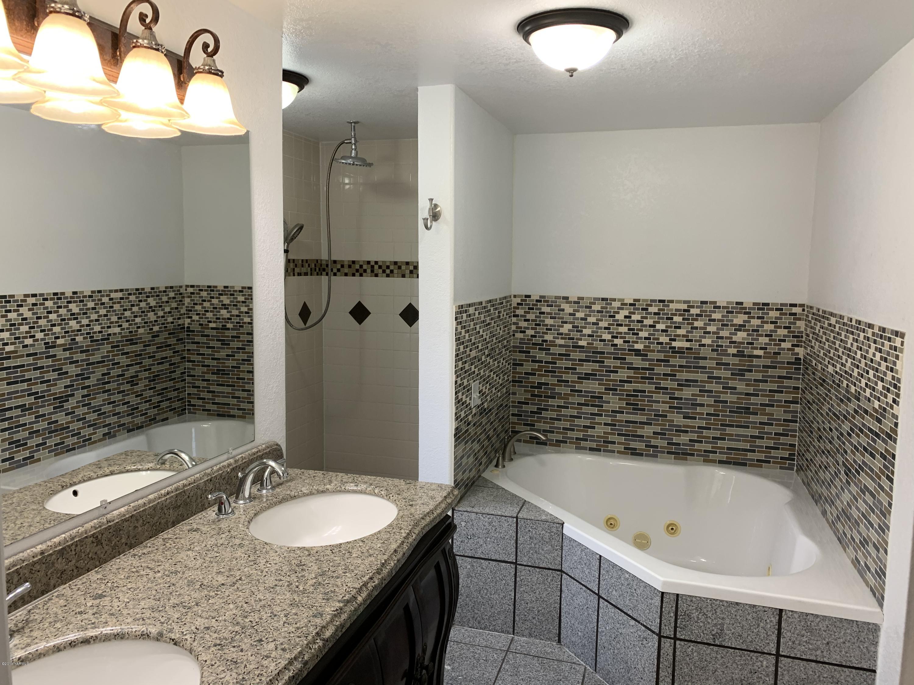 7062 Emerald Road Sunnyside, WA 98944 - Photo 22 of 37 a bathroom with a granite countertop sink and a bathtub