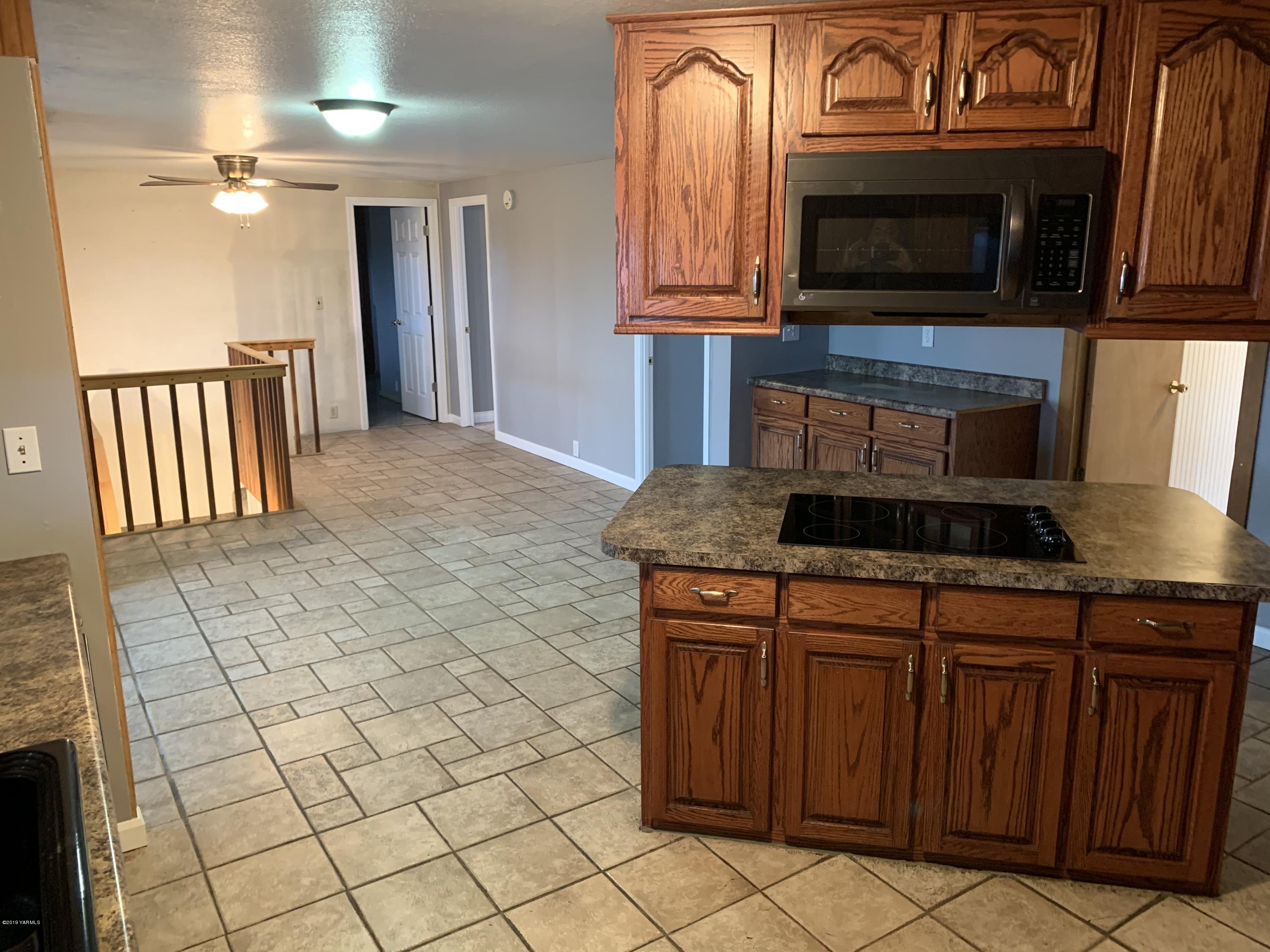 7062 Emerald Road Sunnyside, WA 98944 - Photo 28 of 37 a kitchen with granite countertop a stove a microwave and a sink