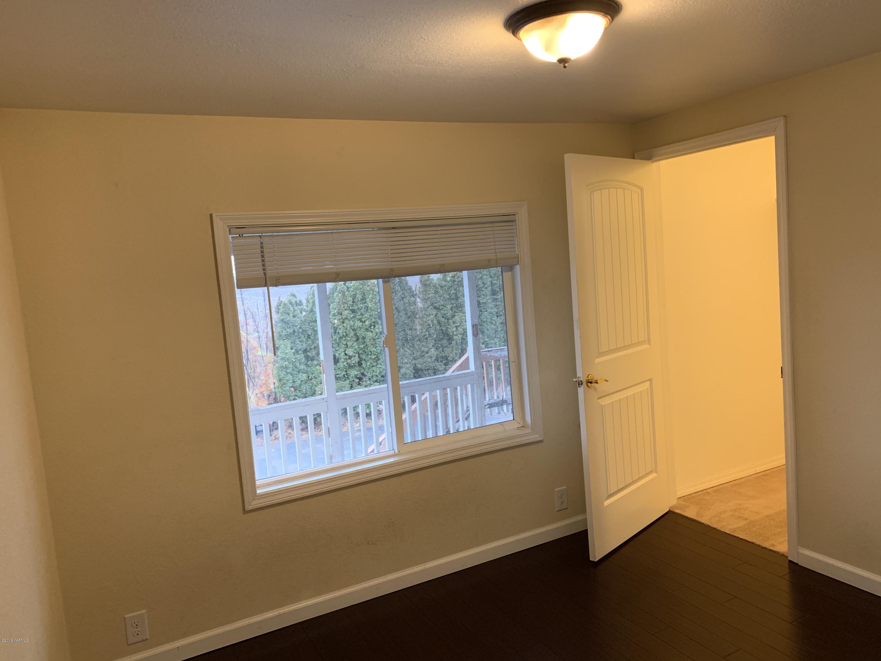 7062 Emerald Road Sunnyside, WA 98944 - Photo 32 of 37 a view of an empty room with wooden floor and windows