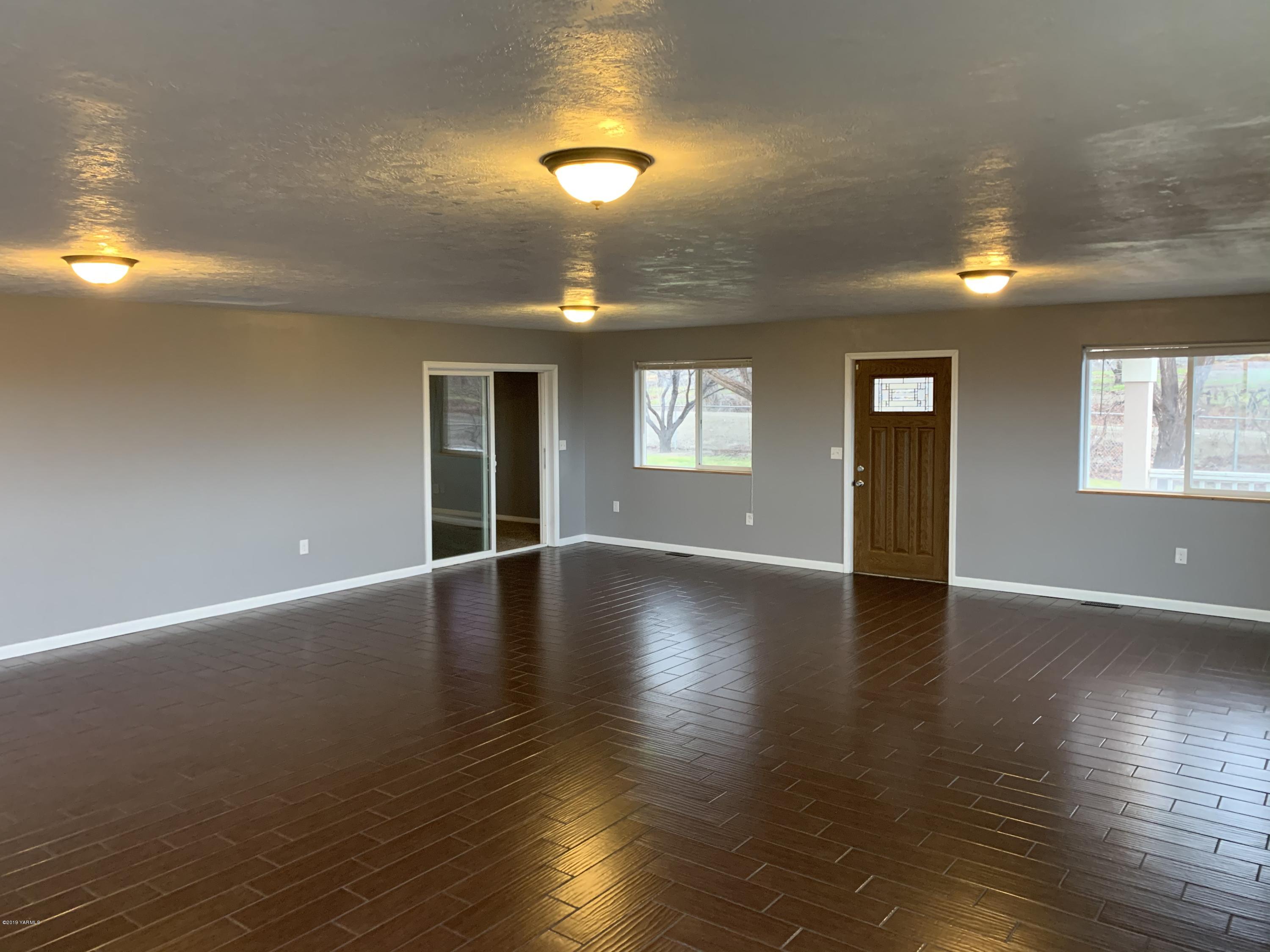 7062 Emerald Road Sunnyside, WA 98944 - Photo 35 of 37 a view of an empty room with wooden floor and a window