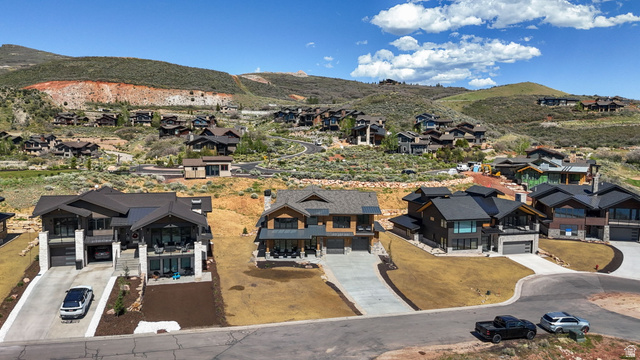 10646 North Reflection Ridge Hideout, UT 84036 - Photo 38 of 43 Contemporary mountain-style residence featuring a dark-toned exterior with expansive windows, two prominent balconies, and a two-car garage