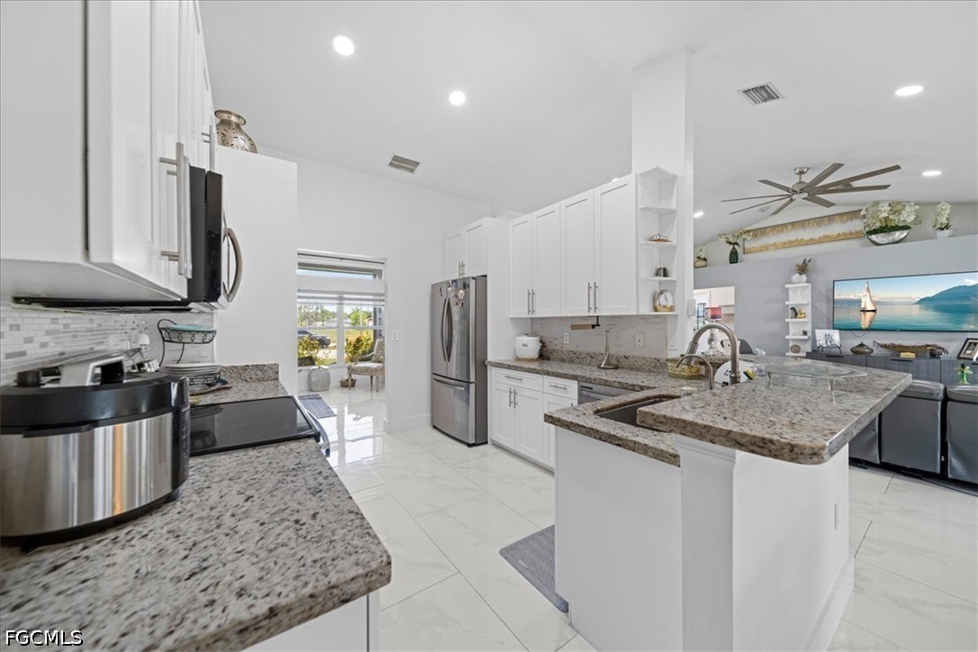 22 Nelson Road South Cape Coral, FL 33991 - Photo 15 of 43 a kitchen with stainless steel appliances granite countertop a sink stove and refrigerator