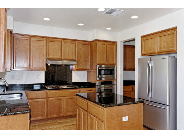 111 Alvo Court San Ramon, CA 94582 - Photo 3 of 17 a kitchen with kitchen island granite countertop a refrigerator a sink a stove a microwave and island