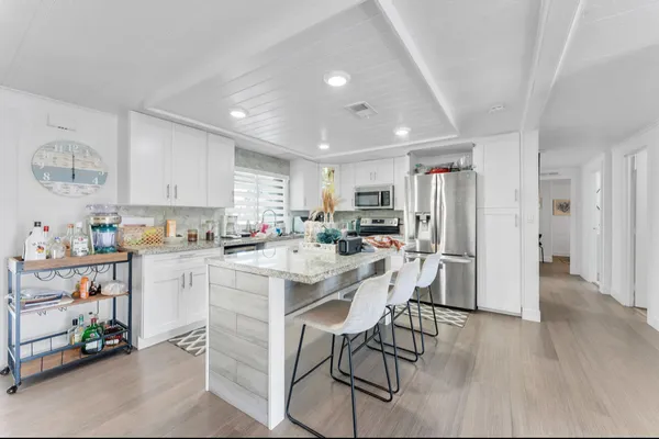 a kitchen with a refrigerator a dining table and chairs