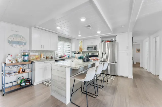 a kitchen with a refrigerator a dining table and chairs