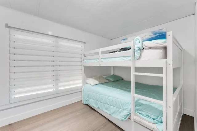 a view of a park that has a sign board large trees and plants