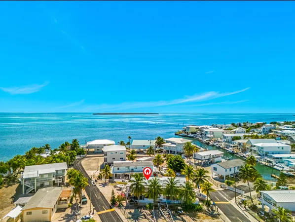 a view of a terrace with a table and chairs under an umbrella next to a yard