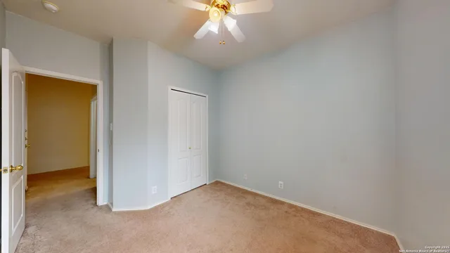 an empty room with a ceiling fan and a window