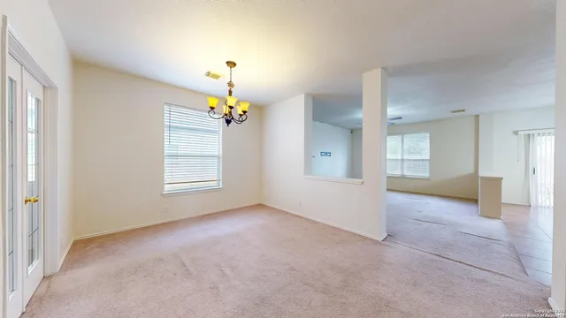 an empty room with windows and chandelier