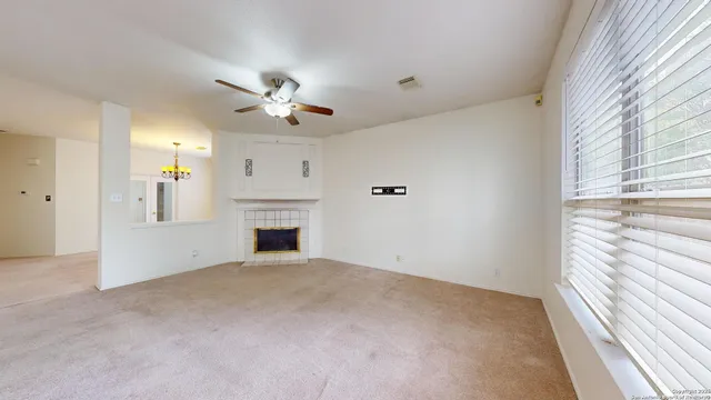 a view of a livingroom with a fireplace and ceiling fan