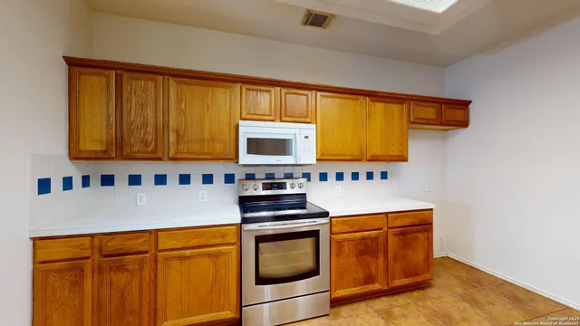 a kitchen with stainless steel appliances granite countertop white cabinets sink and a stove