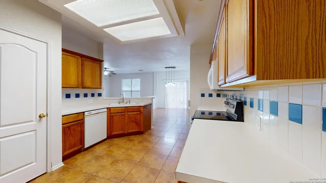 a large kitchen with stainless steel appliances a stove a sink and a microwave