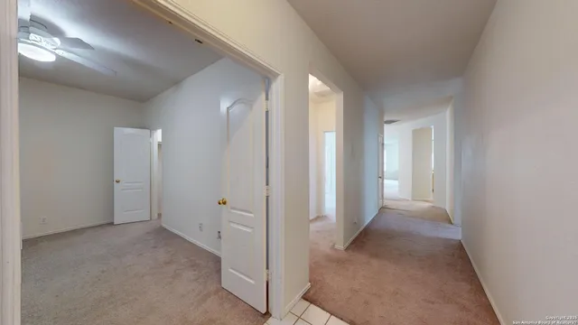 a view of a hallway to rooms