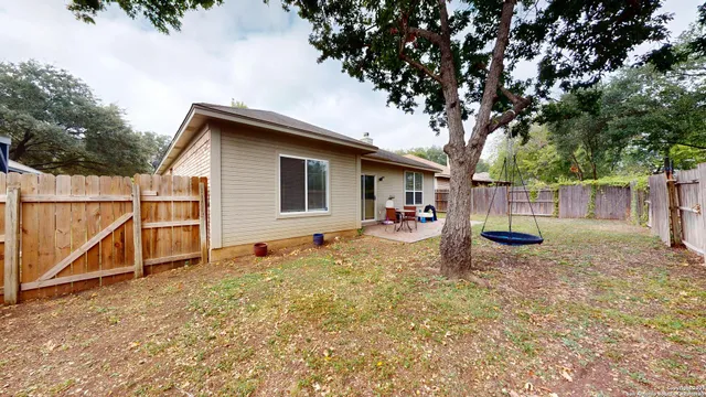 a view of a house with backyard and a tree