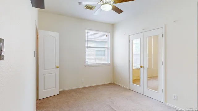 an empty room with closet and chandelier fan