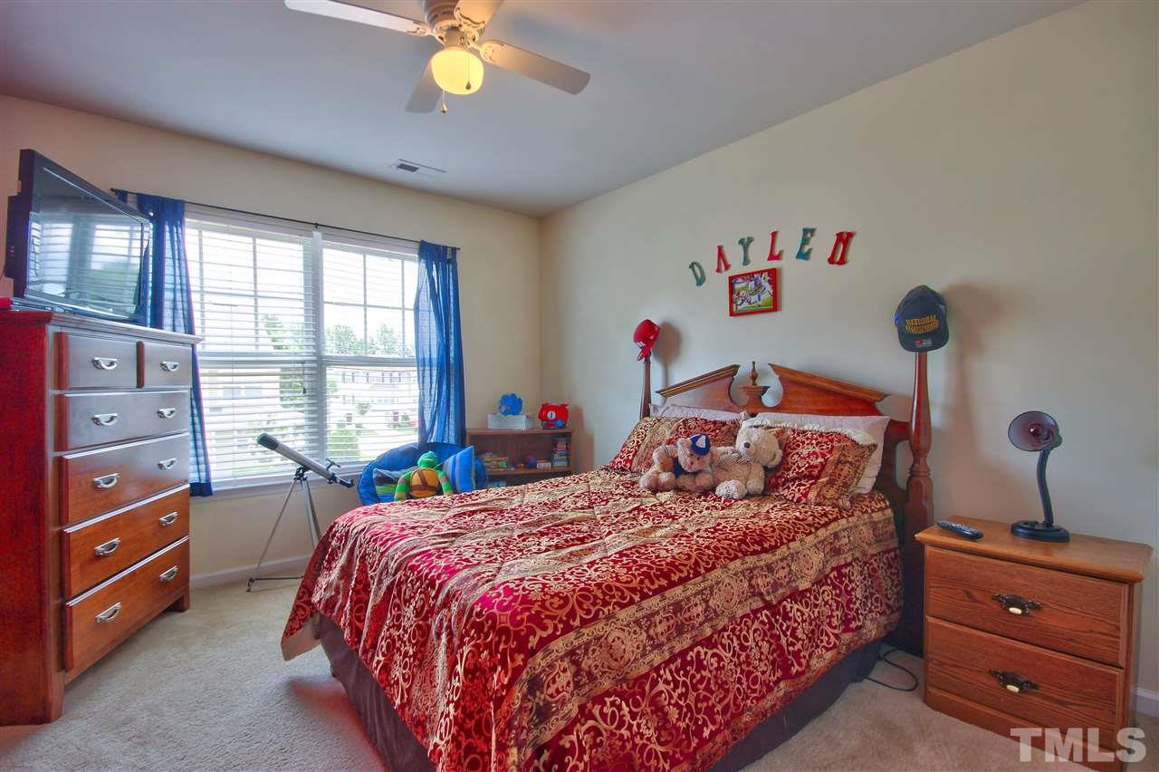 5116 Sandy Banks Road Raleigh, NC 27616 - Photo 16 of 21 a bedroom with a bed and a chandelier
