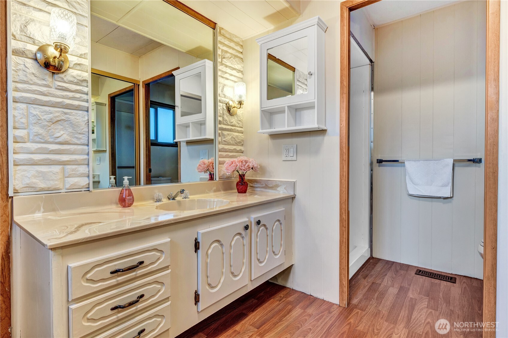 18425 Northeast 95th Street, Unit 110 Redmond, WA 98052 - Photo 11 of 25 a bathroom with a sink a mirror and a shower