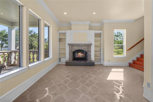 a view of an empty room with window and fire place