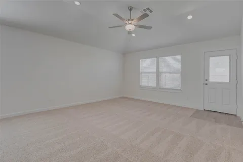 an empty room with a window and a ceiling fan