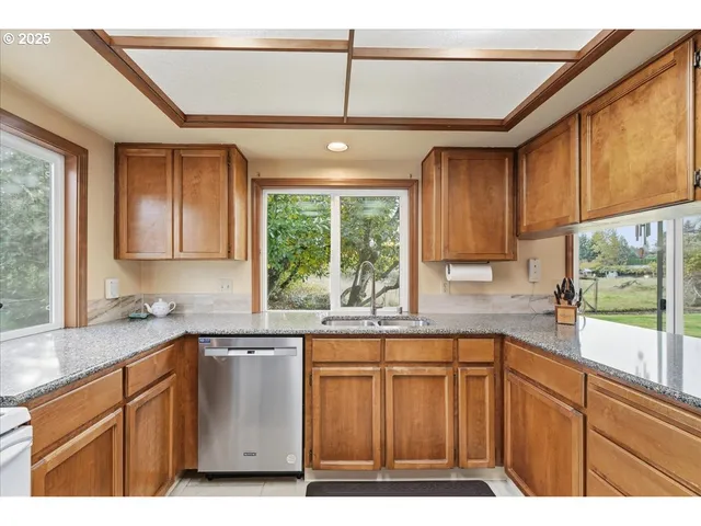 a kitchen with a sink window and cabinets