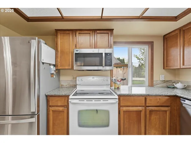 a kitchen with stainless steel appliances granite countertop a refrigerator a stove a sink and dishwasher