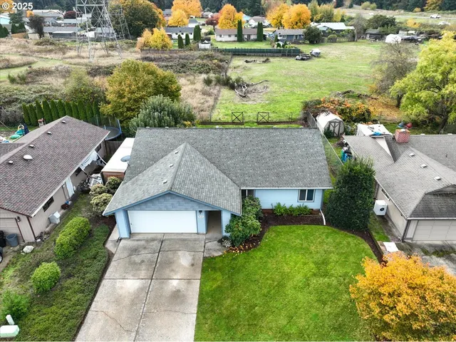 an aerial view of a house with a yard and lake view