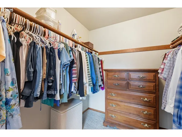 a view of walk in closet with clothes
