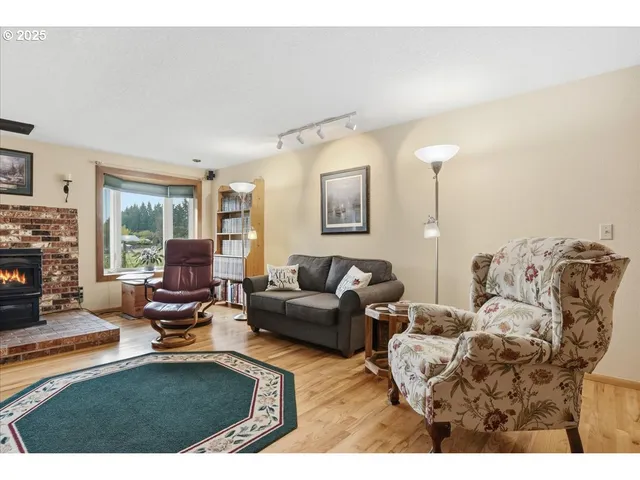 a living room with furniture a fireplace and a large window