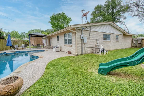 a view of a house with a backyard and a slide