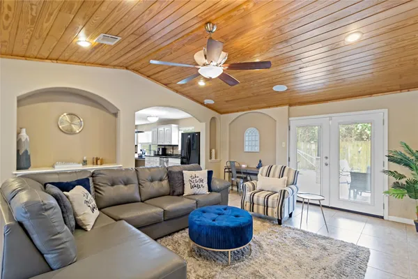 a living room with furniture a large window and a chandelier