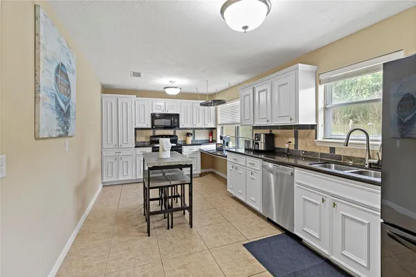 a kitchen with cabinets a sink and appliances