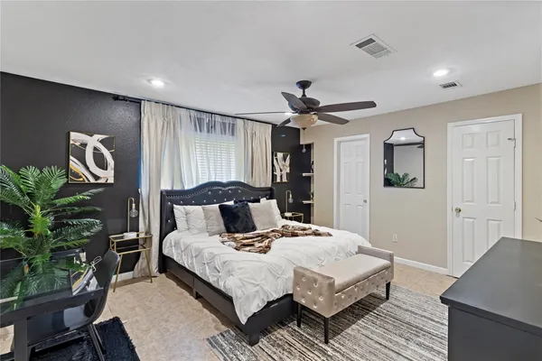 a bedroom with a large bed and a potted plant