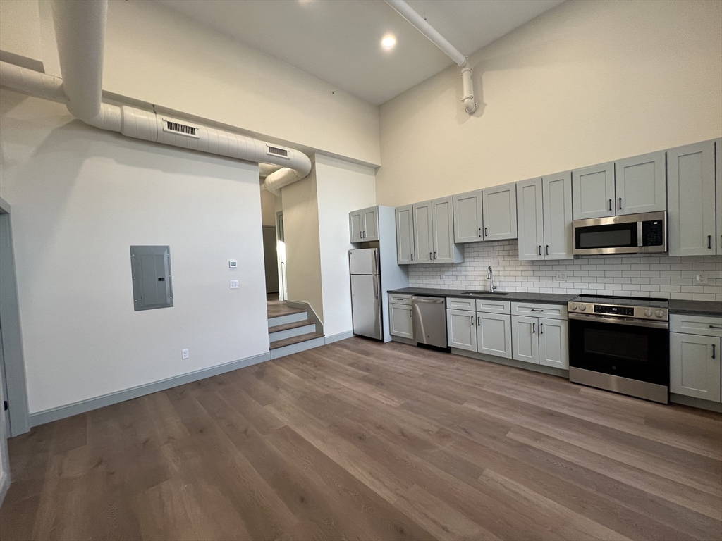 a large kitchen with stainless steel appliances granite countertop a stove and a sink