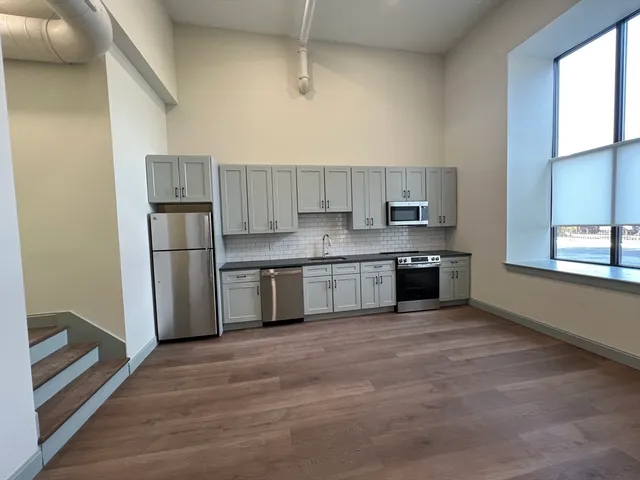 a kitchen with stainless steel appliances granite countertop a refrigerator sink and stove