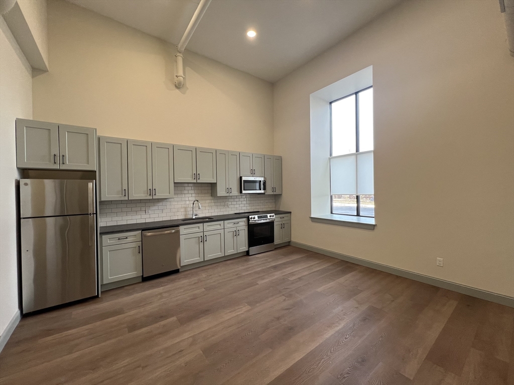 160 Seabury Street, Unit 16 Fall River, MA 02720 - Photo 3 of 11 a kitchen with granite countertop a refrigerator and wooden cabinets