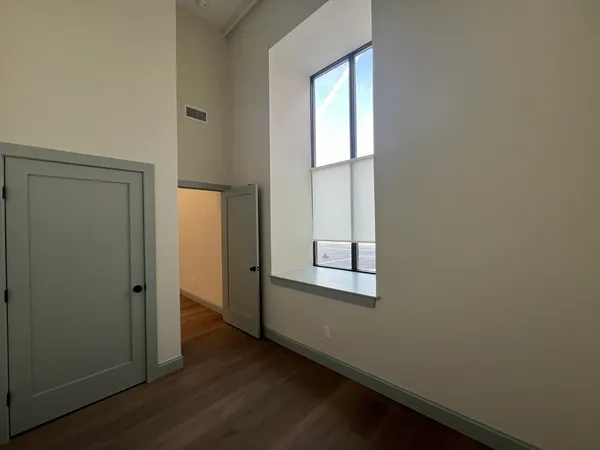 an empty room with wooden floor and windows