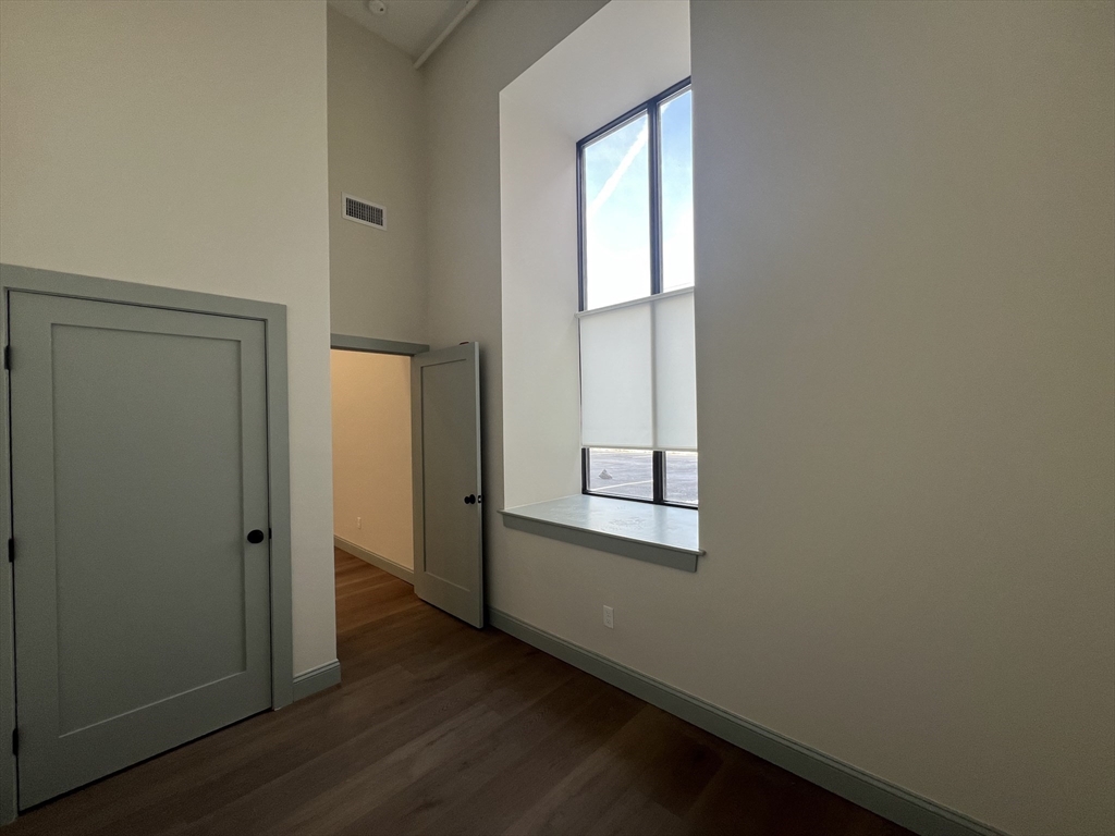 160 Seabury Street, Unit 16 Fall River, MA 02720 - Photo 5 of 11 an empty room with wooden floor and windows
