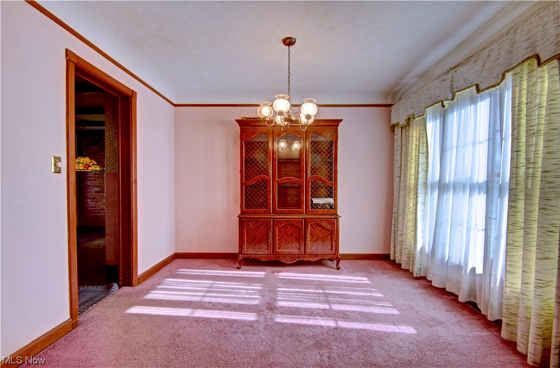 20930 Eaton Road Cleveland, OH 44126 - Photo 13 of 33 Empty room with light colored carpet, an inviting chandelier, and crown molding