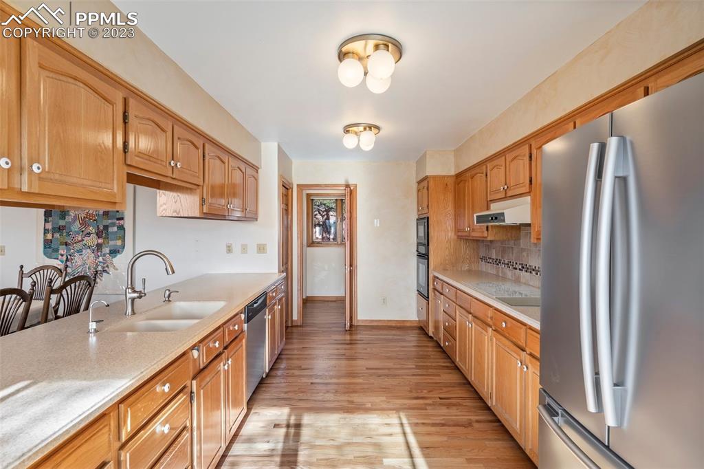 1711 Columbine Road Colorado Springs, CO 80907 - Photo 12 of 50 a hallway with stainless steel appliances granite countertop a sink and a refrigerator