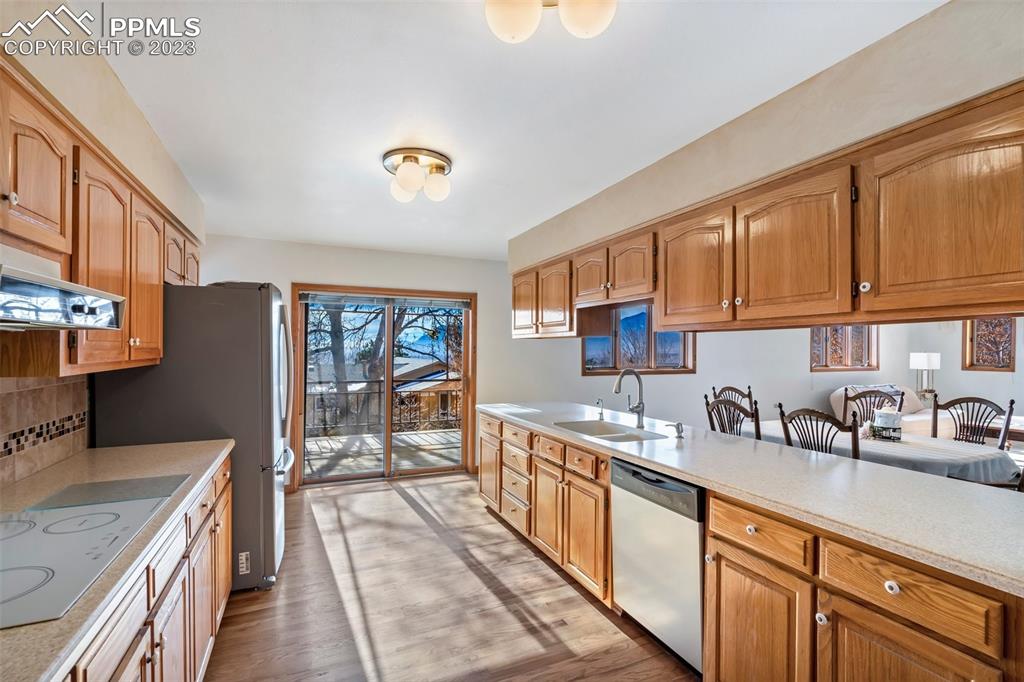 1711 Columbine Road Colorado Springs, CO 80907 - Photo 13 of 50 a kitchen with stainless steel appliances a sink dishwasher stove refrigerator and cabinets