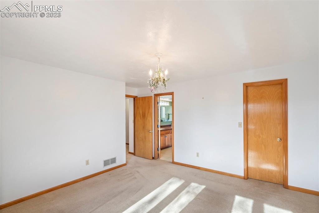 1711 Columbine Road Colorado Springs, CO 80907 - Photo 21 of 50 a view of an empty room with window and chandelier fan