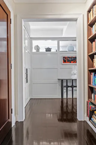a view of a hallway with wooden floor and dining room