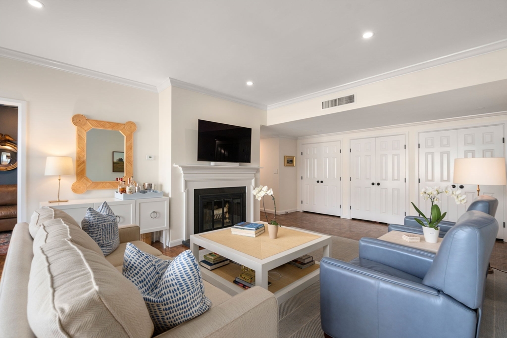 75 Grove Street, Unit 429 Wellesley, MA 02482 - Photo 1 of 22 a living room with furniture a fireplace and a flat screen tv