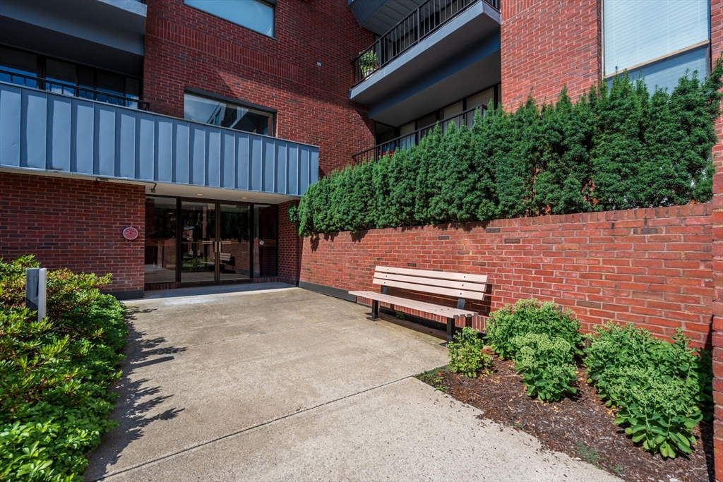 75 Grove Street, Unit 429 Wellesley, MA 02482 - Photo 20 of 22 a view of a patio with table and chairs with wooden fence and plants