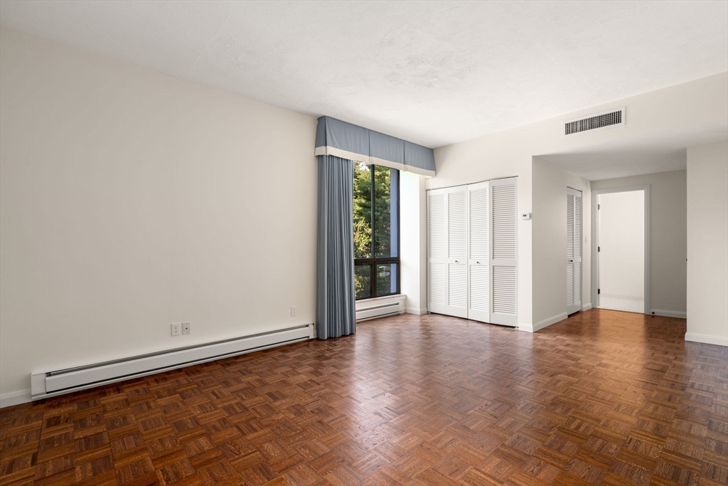 75 Grove Street, Unit 429 Wellesley, MA 02482 - Photo 8 of 22 a view of an empty room with wooden floor and a window